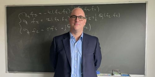 Mattia Zanella, sullo sfondo lavagna con formula matematica