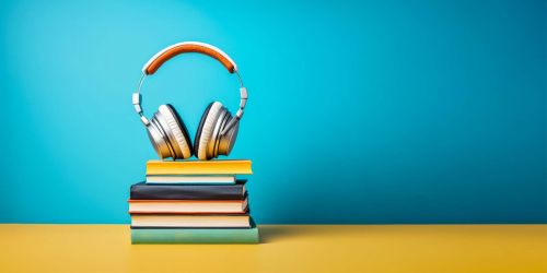 Pila di libri sormontata da cuffie per ascoltare musica