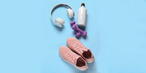 Cuffie per ascoltare musica, scarpe da ginnastica, pesi e borraccia