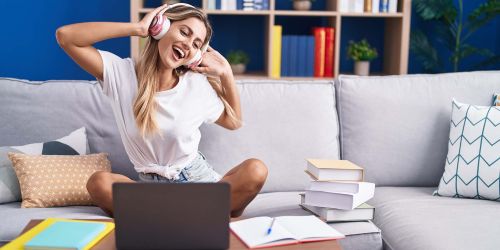 Studentessa sul divano ascolta musica in pausa dallo studio