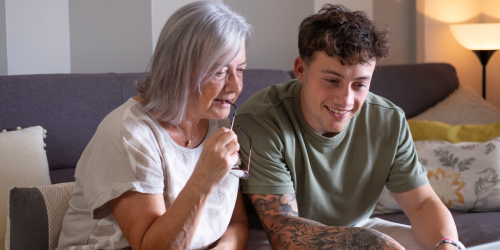 Giovane mostra a una donna anziana come usare il computer