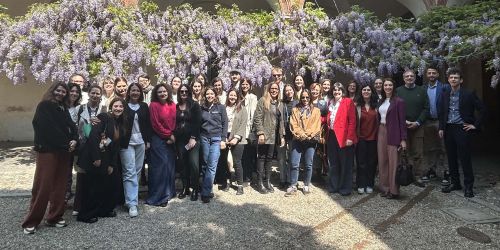 I partecipanti all'evento “Marketing e Reclutamento Internazionale: analisi e strumenti” nel Cortile Sforzesco con il glicine fiorito