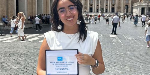 Sjria Murgia a Roma davanti a S. Pietro con in mano la targa del riconoscimento ricevuto.