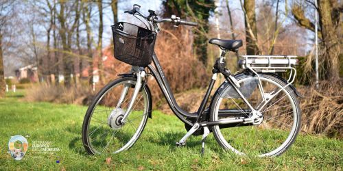 Bicicletta su un prato. In basso a sinistra il logo della Settimana Europea della Mobilità