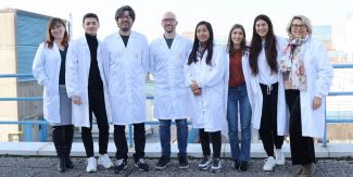 Gruppo di ricerca del laboratorio di archeogenomica, 8 persone a figura intera con camice