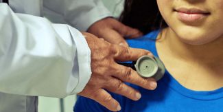 Pediatra che visita bambina con stetoscopio, dettaglio