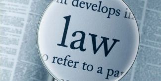 Grafica con la parola "law" in primo piano dietro una lente di ingrandimento