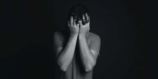 Giovane con il viso tra le mani, foto in bianco e nero