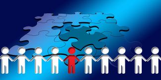 Puzzle con ultima tessera da sistemare e uomini stilizzati che si danno la mano