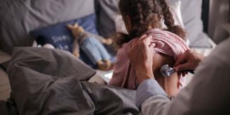 Pediatra che ausculta bambina