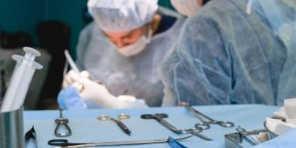 Sala operatoria durante operazione chirurgica: medici al lavoro e vassoio strumenti