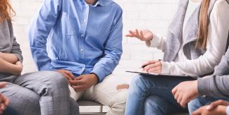 Terapia di gruppo, persone in circolo, dettaglio dei busti e delle mani