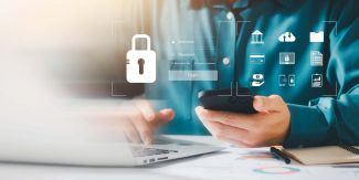 Persona al pc che tiene in mano un cellulare. In sovrimpressione disegno di campi username e password e un lucchetto per sicurezza informatica