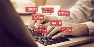 Mani di persona al computer, in sovrimpressione parole d'odio