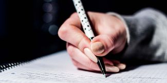 Mano femminile che scrive su quaderno