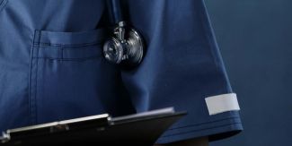 Dettaglio del camice di un'infermiera con stetoscopio e cartellina