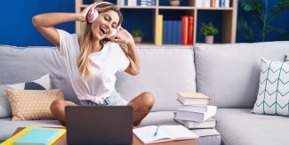 Studentessa sul divano ascolta musica in pausa dallo studio