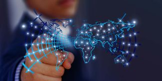 Uomo punta il dito su immagine di un planisfero con rete connessioni simbolo di tecnologia e intelligenza artificiale