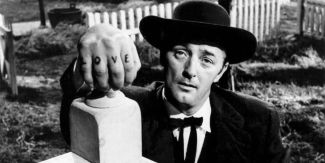 Robert Mitchum nei panni di Harry Powell protagonista del film "La morte corre sul fiume"