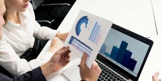 Uomo e donna in ufficio analizzano dei grafici