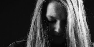 Giovane ragazza col capo chino. Foto in bianco e nero