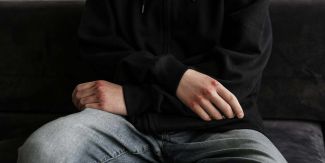 Dettaglio delle mani di un ragazzo con le nocche ferite