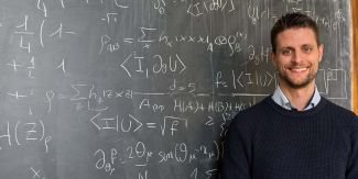 Giacomo Guarnieri davanti a una lavagna con formule