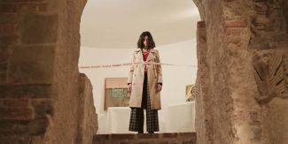 Ragazza nel Museo Diocesano di Pavia dietro a nastro con la scritta "fragile"