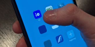 Schermata di un cellulare con mano che clicca su App Io