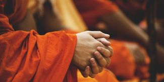 Mani intrecciati di monaco buddista