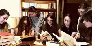 Studentesse sedute a un tavolo intente a leggere