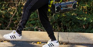 Dettaglio su gambe di persona che regge in mano uno stereo anni '80