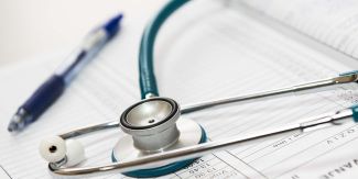 Stetoscopio appoggiato su registro insieme a una penna