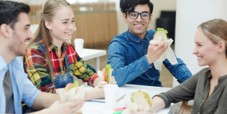 Giovani seduti a un tavolo mentre mangiano