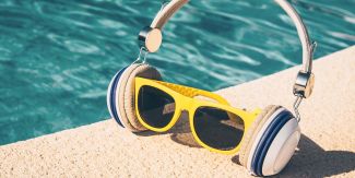 Cuffie per ascoltare musica poste a bordo piscina. Al loro interno degli occhiali da sole
