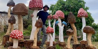 Michel Vecchi tra le sue sculture a forma di fungo