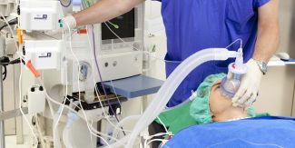 Paziente sul tavolo operatorio, dietro di lei busto dell'anestesista