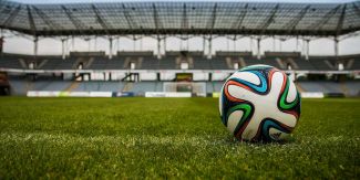 Pallone da calcio appoggiato sul campo in uno stadio