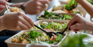 Piatti con verdure e cibi sani e mani con forchette