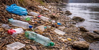 Riva di un fiume con rifiuti plastici