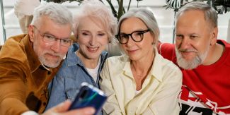 Gruppo di anziani (due donne e due uomini) che stanno facendo un selfie