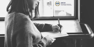 Donna che scrive. In sovrimpressione loghi del Cral UniPv e di ANCIU