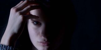 Ragazza triste con metà volto visibile e metà volto al buio