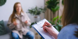 Colloquio psicologico: paziente sfuocata e psicologa di spalle