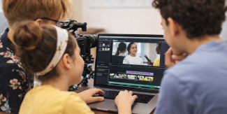Bambini di spalle al lavoro su un computer portatile
