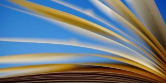 Primo piano sulle pagine di un libro aperto. Sullo sfondo cielo azzurro