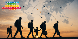 Silhouette di un gruppo di persone con zaini e borse in cammino al tramonto. Sullo sfondo del cielo arancione si staglia una mappa del mondo stilizzata con linee tratteggiate e frecce che collegano diversi continenti. In alto a sinistra è presente il logo del "Festival dello Sviluppo Sostenibile 2026".