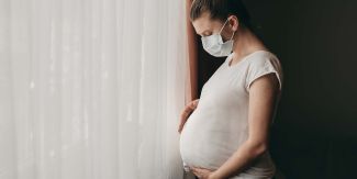 Donna in gravidanza che indossa una mascherina