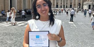 Sjria Murgia a Roma davanti a S. Pietro con in mano la targa del riconoscimento ricevuto.
