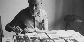 Primo Levi seduto alla scrivania piena di libri